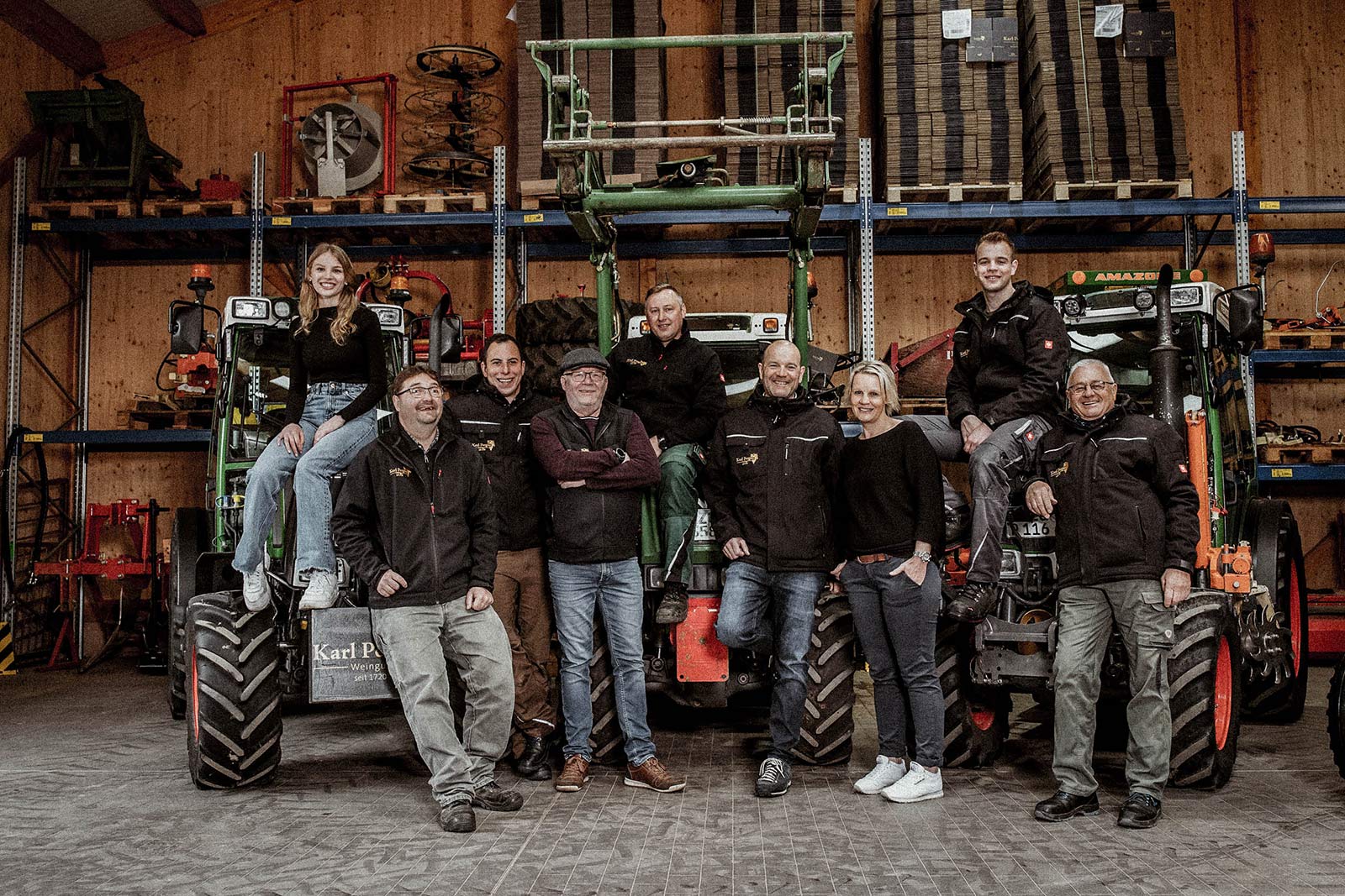 Wein aus dem Saarland – Weingut Karl Petgen – Team vor den Traktoren